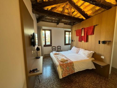 - une chambre avec un grand lit et un plafond en bois dans l'établissement TRA SAN MARCO E RIALTO, à Venise