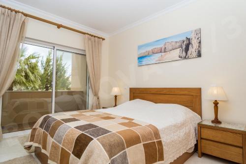 een slaapkamer met een bed en een groot raam bij Boa Nova Plot 3 apt 31 in Carvoeiro