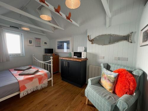 Un dormitorio con una cama, un sofá y una silla. en Cilia Marys Annexe St Teath, en Saint Teath