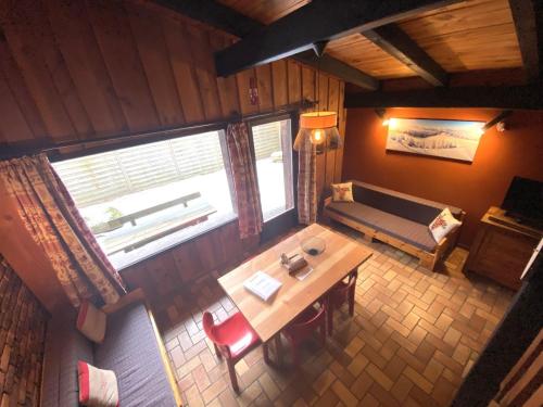 vistas panorámicas a una sala de estar con mesa y sofá en LA POMME DE PIN 1 Appartement avec terrasse, en La Bresse