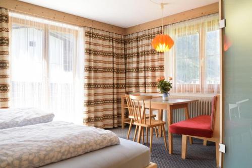 1 dormitorio con mesa, 1 cama y comedor en Haus Kohler, en Häselgehr