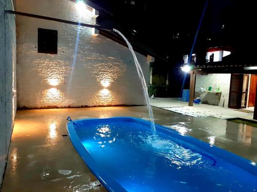 uma banheira azul com uma fonte de água em Casa ÍSIS de aluguel por temporada em Capão da Canoa com piscina em Capão da Canoa