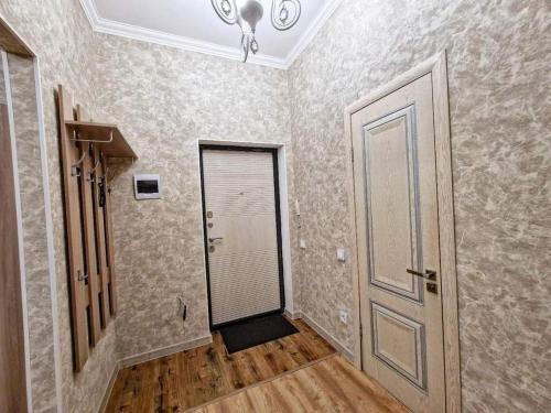 an empty hallway with a door and a room with wooden floors at ЖК Чемпион in Taldykolʼ