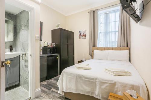 a bedroom with a large bed and a bathroom at BeiRoom Hyde Park Apartments in London