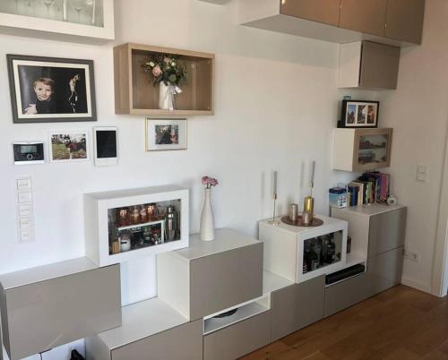 uma sala de estar com mobiliário branco e quadros na parede em Rooftop apartment in and over Vienna em Viena