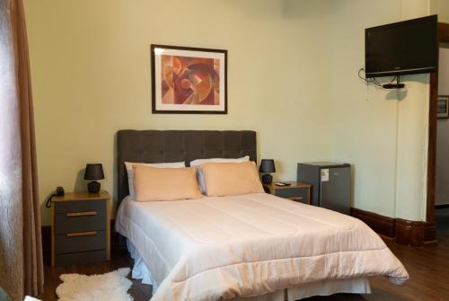 a bedroom with a bed and a flat screen tv at Coliving Med by Hotel Mediterràneo in Montevideo
