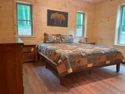 a bedroom with a bed in a log cabin at Blissful Bear in Old Forge