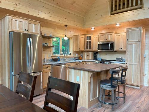 a kitchen with a stainless steel refrigerator and wooden cabinets at Blissful Bear in Old Forge