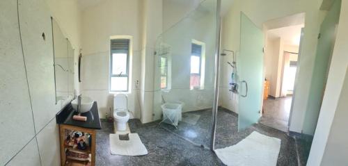 a bathroom with a toilet and a glass shower at Nile retreat in Jinja