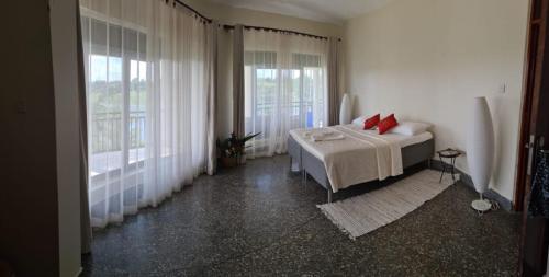 a bedroom with a bed and two windows at Nile retreat in Jinja