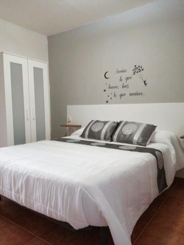 1 dormitorio con 1 cama con edredón blanco en Reposo tranquilo en entorno rural, en Cetina