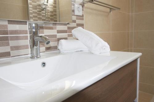 a bathroom with a sink and a mirror and towels at Apartment Jara, Tavira in Tavira