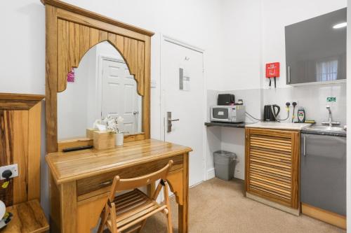a kitchen with a wooden desk and a sink at BeiRoom Hyde Park Apartments in London