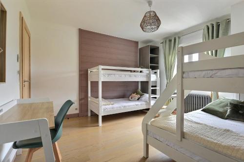 a small room with two bunk beds and a table at Gîte Les Libellules - 12 personnes - 4 étoiles - Spa in Fresse-sur-Moselle