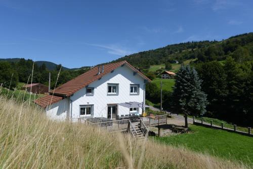 a white house in the middle of a field at Gîte Les Libellules - 12 personnes - 4 étoiles - Spa in Fresse-sur-Moselle
