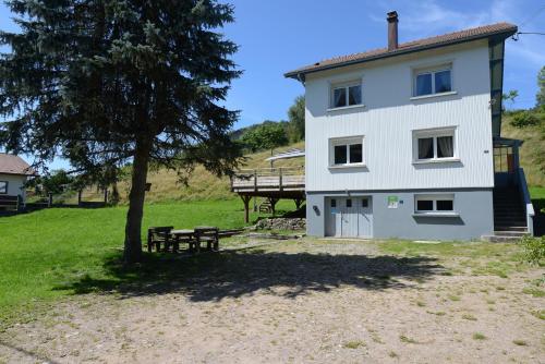 a white house with a tree and a bench at Gîte Les Libellules - 12 personnes - 4 étoiles - Spa in Fresse-sur-Moselle