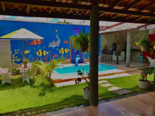 een kamer met een zwembad met een vismuurschildering bij Recanto Girassol in Aquiraz