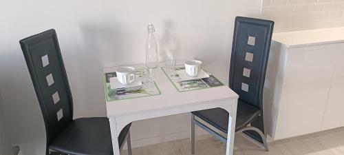 a white table and chairs with two mugs on it at ciel étoilé in Vallauris