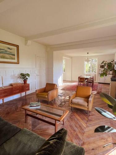 - un salon doté de meubles et d'un piano dans l'établissement Villa Azur, à Azur