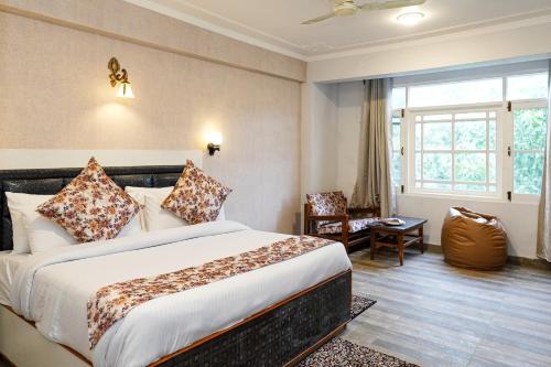 una camera d'albergo con letto e sedia di Click Sunburry Hotel Srinagar a Srinagar