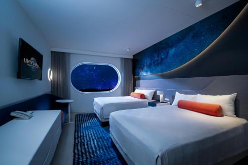 a hotel room with two beds and a window at Universal's Stella Nova Resort in Orlando
