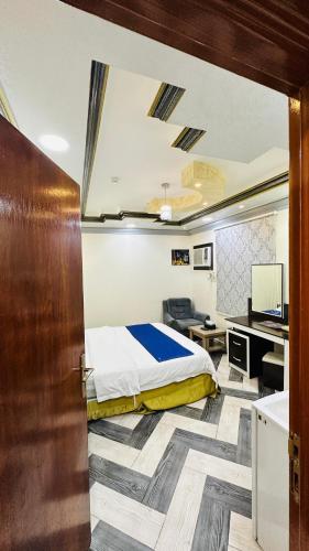 um quarto com uma cama e uma secretária com um computador em أجنحة بلو روز الفندقية em Najran