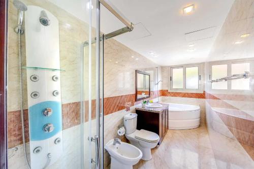 e bagno con servizi igienici, lavandino e doccia. di Villa Harmonia - 4 Bedroom Luxury Beach Front Villa with Private Pool a Polis Chrysochous