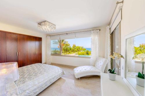 una camera con un letto e una grande finestra di Villa Harmonia - 4 Bedroom Luxury Beach Front Villa with Private Pool a Polis Chrysochous