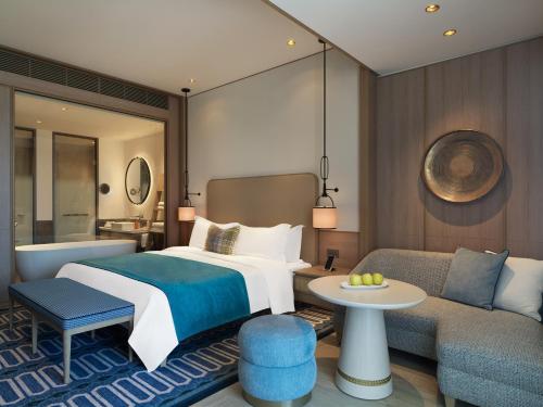 um quarto de hotel com uma cama e um sofá em City of Dreams Mediterranean - Integrated Resort, Casino & Entertainment em Limassol