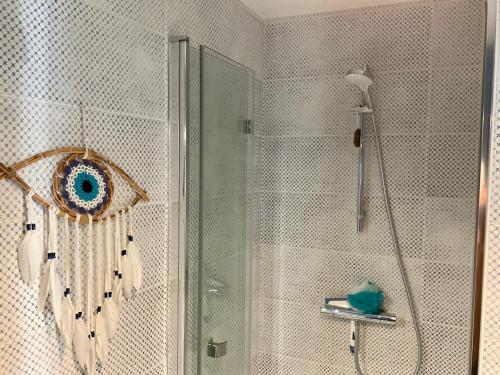 a bathroom with a shower with a glass door at Le Nid Douillet, studio avec terrasse et parking à 400m des plages in Larmor-Plage