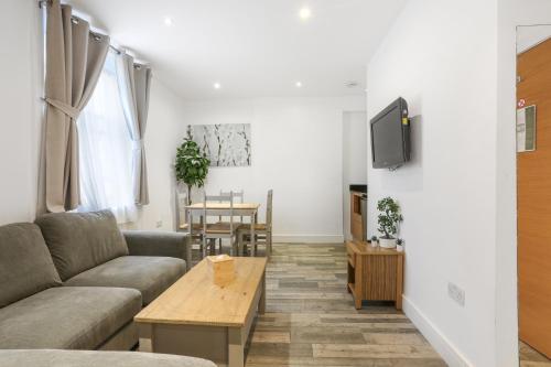 a living room with a couch and a table at BeiRoom Hyde Park Apartments in London
