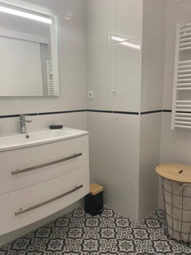 une salle de bain blanche avec un lavabo et un miroir dans l'établissement Le Boisé - À deux pas de Paris - 320B, à Rueil-Malmaison