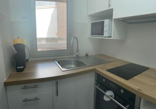 une cuisine avec un évier et un micro-ondes dans l'établissement Le Boisé - À deux pas de Paris - 320B, à Rueil-Malmaison