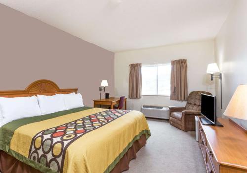une chambre d'hôtel avec un lit et une chaise dans l'établissement Quality Inn, à Huntington