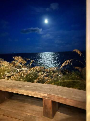 a wooden bench overlooking the ocean at night at Palmetto Breeze, Golf Course New furniture, carpet in Johns Island