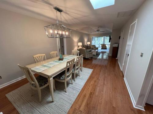 a dining room and living room with a table and chairs at Palmetto Breeze, Golf Course New furniture, carpet in Johns Island