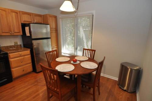 a kitchen with a table with chairs and a refrigerator at Palmetto Breeze, Golf Course New furniture, carpet in Johns Island