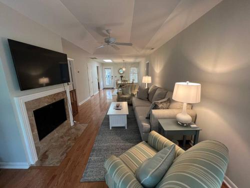 a living room with a couch and a fireplace at Palmetto Breeze, Golf Course New furniture, carpet in Johns Island