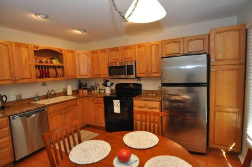 a kitchen with wooden cabinets and a stainless steel refrigerator at Palmetto Breeze, Golf Course New furniture, carpet in Johns Island