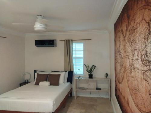 1 dormitorio con 1 cama y una gran pintura en la pared en Private Guest House 2 bedrooms & 2 baths near Grace Bay Beach & Long Bay Beach. en Providenciales