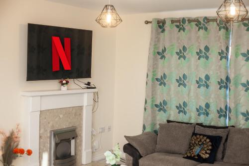 a living room with a couch and a fireplace at Avril Warwickshire Home Stay in Nuneaton