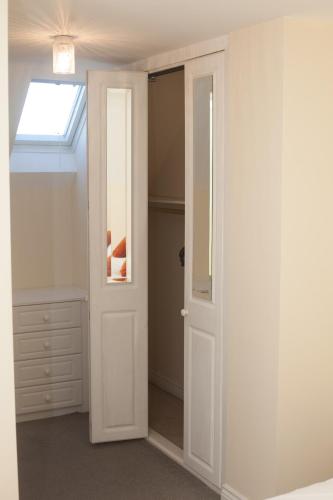 a bedroom with an open door and a window at Avril Warwickshire Home Stay in Nuneaton