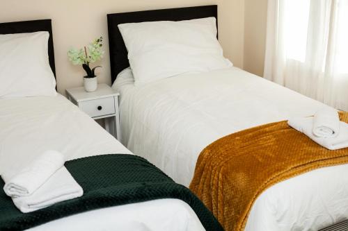 1 dormitorio con 2 camas y toallas en Avril Warwickshire Home Stay, en Nuneaton