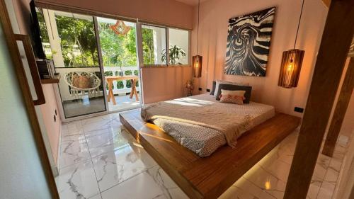 1 dormitorio con cama y ventana grande en Ocean Palms Residences, en Cabarete
