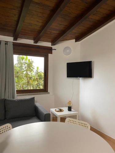 a living room with a table and a tv at Casa Vacanza Porta Smeralda in Olbia
