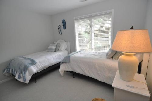 a bedroom with two beds and a lamp on a table at Palmetto Breeze, Golf Course New furniture, carpet in Johns Island