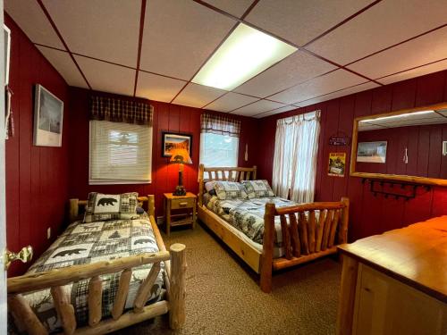 two beds in a room with red walls at Ryder's Lodge in Old Forge