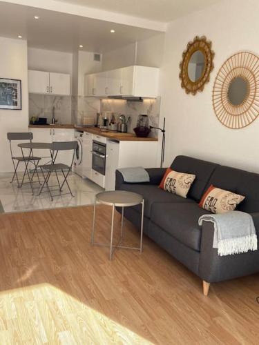 un salon avec un canapé et une cuisine dans l'établissement Le Studio 21 Carlotta, à Villers-sur-Mer