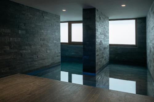 a room with a swimming pool and two windows at ISARD RESIDENCES & SPA by Vip Residences in El Tarter