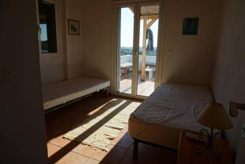 una camera da letto con un letto e una porta su un patio di Haus mit Pool im Olivenhain a Koroni